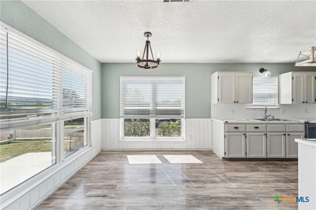 3400 Sally Cir, Kempner, TX 76539 - kitchen with a sink, plenty of natural light, wainscoting, a textured ceiling, and light countertops