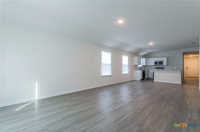 unfurnished living room featuring hardwood / wood-style flooring and vaulted ceiling