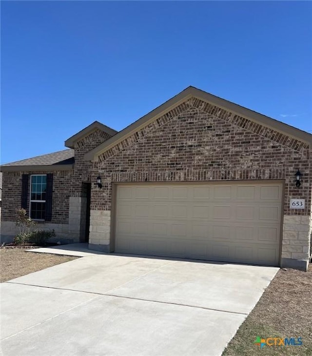 view of front of property with concrete driveway, a garage, and brick siding