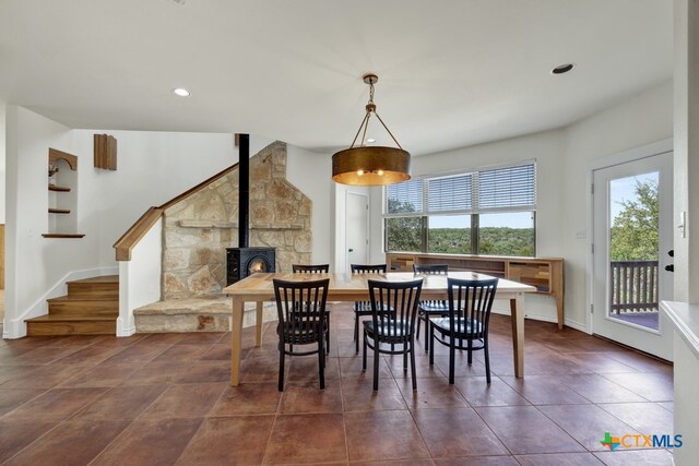 tiled dining space with a wealth of natural light and a wood stove