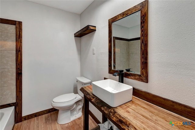 2901 Lone Tree Rd, Victoria, TX 77901 - bathroom featuring wood finished floors, vanity, and a textured wall