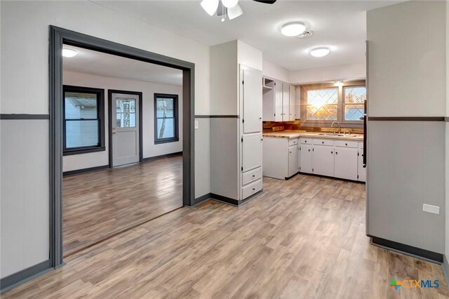 2901 Lone Tree Rd, Victoria, TX 77901 - kitchen with ceiling fan, white cabinetry, light wood-style floors, and light countertops