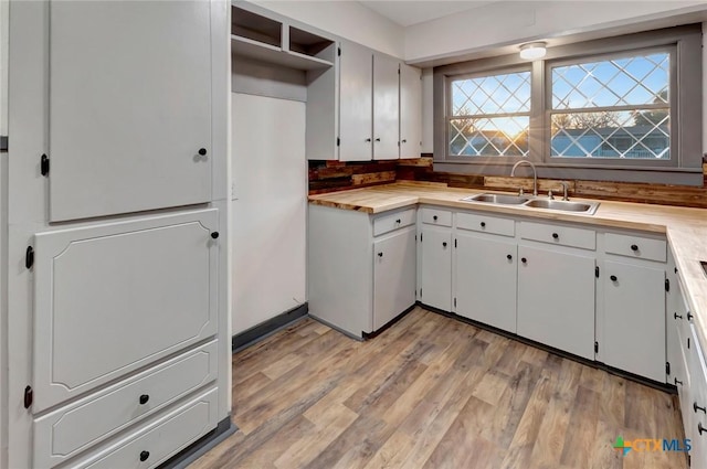 2901 Lone Tree Rd, Victoria, TX 77901 - kitchen featuring light wood-style floors, backsplash, and white cabinetry