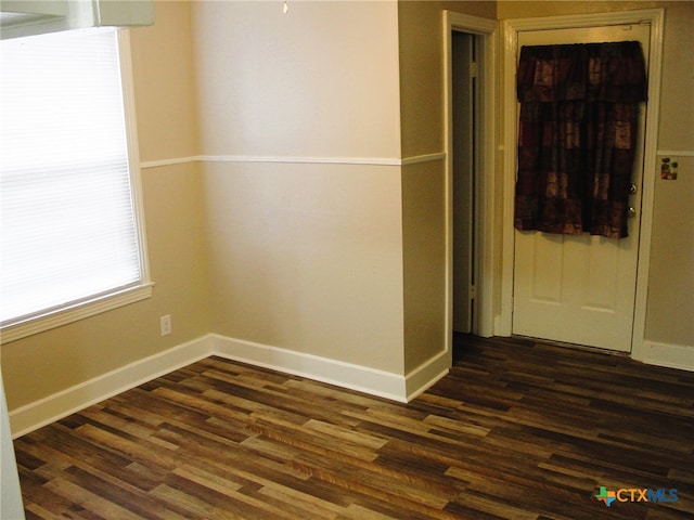 unfurnished room with dark hardwood / wood-style flooring