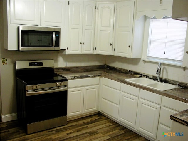 kitchen with white cabinetry, sink, appliances with stainless steel finishes, tasteful backsplash, and dark hardwood / wood-style floors