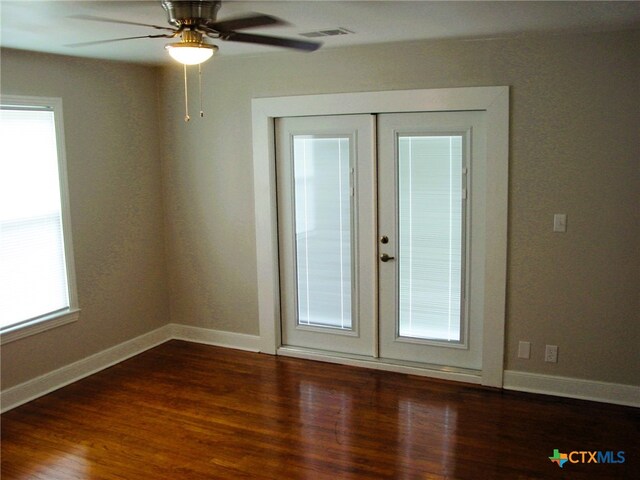 spare room featuring french doors, dark hardwood / wood-style floors, and ceiling fan