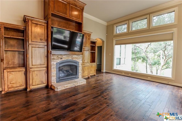 unfurnished living room with dark hardwood / wood-style flooring, ornamental molding, and a fireplace