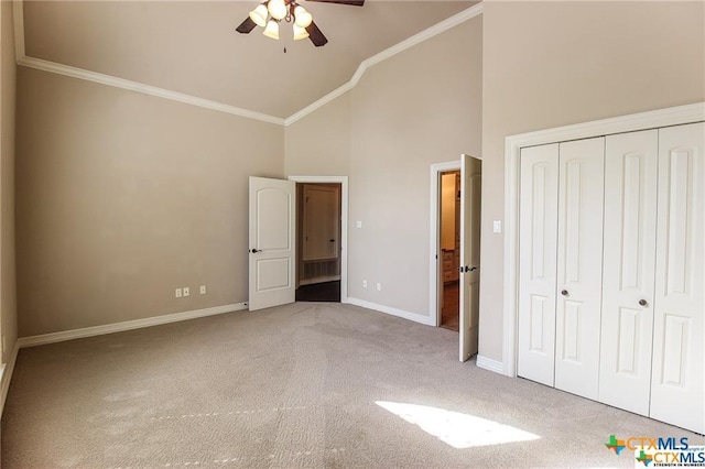 unfurnished bedroom with carpet, ceiling fan, high vaulted ceiling, and a closet