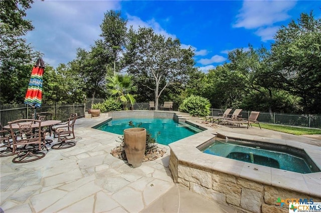 view of swimming pool featuring a patio area and an in ground hot tub