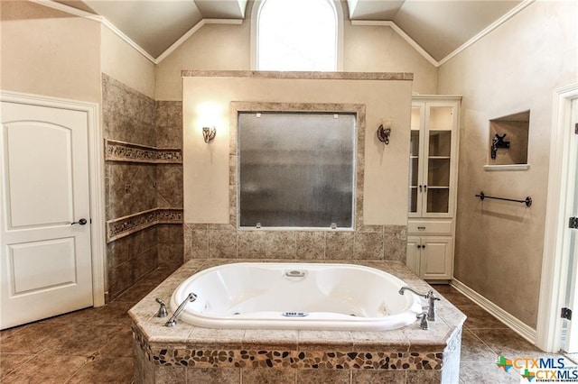 bathroom with tile patterned flooring, ornamental molding, tiled bath, and lofted ceiling