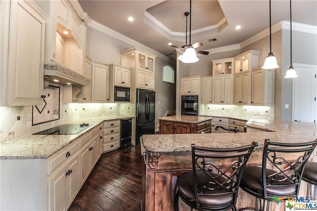 kitchen with a center island, black appliances, dark hardwood / wood-style floors, decorative light fixtures, and a kitchen bar