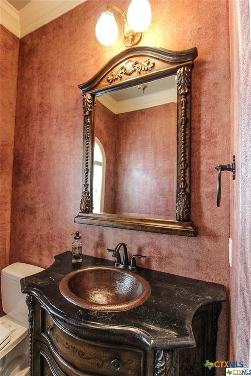 bathroom with vanity, toilet, and crown molding