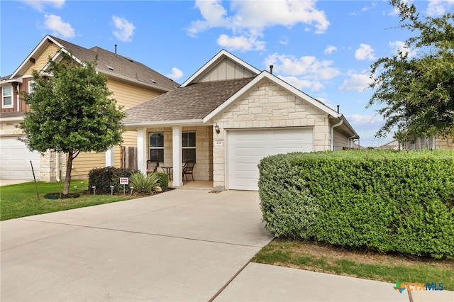 232 Gaida Loop, Georgetown, TX 78628 - view of front of property featuring concrete driveway, a garage, stone siding, board and batten siding, and roof with shingles