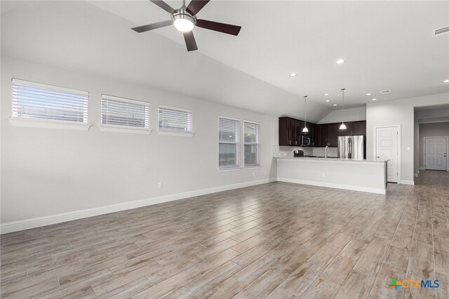 232 Gaida Loop, Georgetown, TX 78628 - unfurnished living room with lofted ceiling, ceiling fan, light wood-style floors, baseboards, and recessed lighting