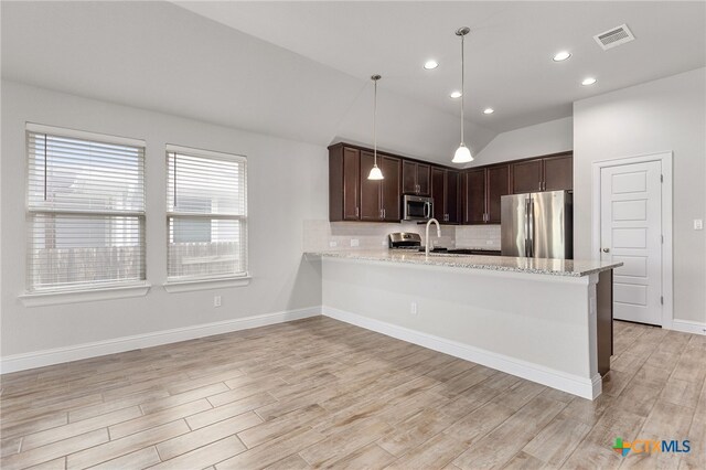 232 Gaida Loop, Georgetown, TX 78628 - kitchen featuring appliances with stainless steel finishes, light wood-style floors, dark brown cabinets, backsplash, and vaulted ceiling