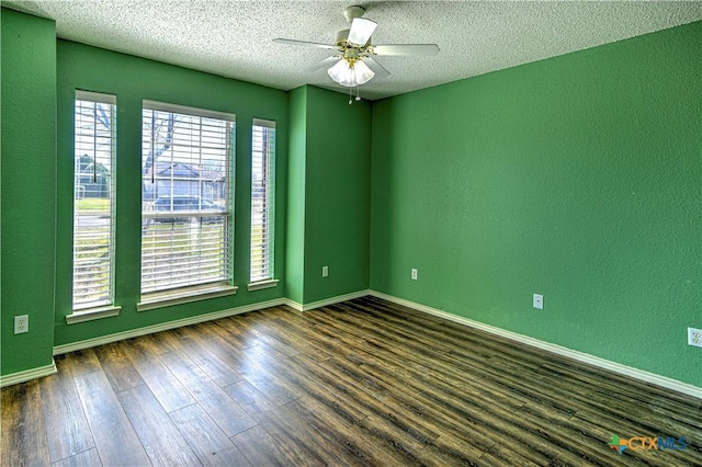 unfurnished room featuring dark wood-style floors, baseboards, ceiling fan, a textured ceiling, and a textured wall