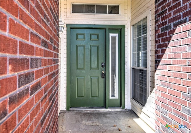 doorway to property featuring brick siding