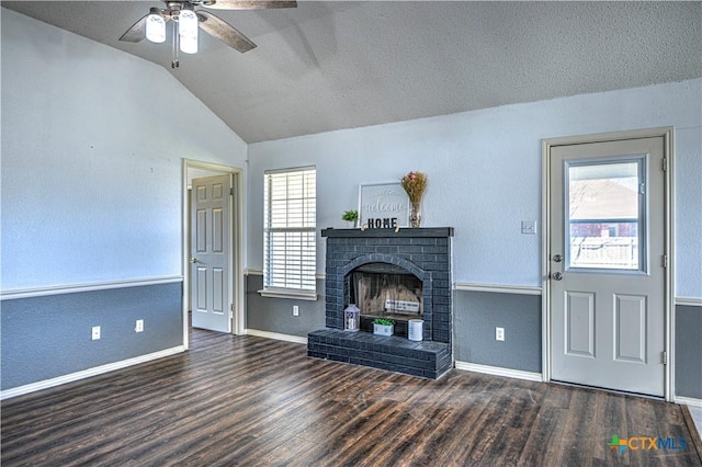 unfurnished living room with baseboards, lofted ceiling, a fireplace, wood finished floors, and a textured ceiling