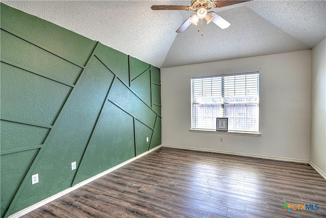 unfurnished room with vaulted ceiling, a textured ceiling, and wood finished floors