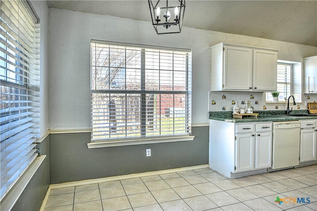 kitchen featuring dishwasher, light tile patterned floors, a textured ceiling, white cabinetry, and a sink