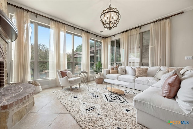 sunroom featuring a brick fireplace and a notable chandelier