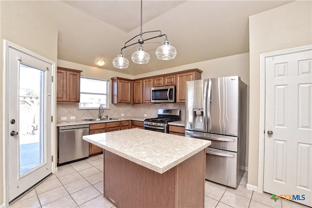 kitchen featuring decorative backsplash, stainless steel appliances, sink, decorative light fixtures, and a center island