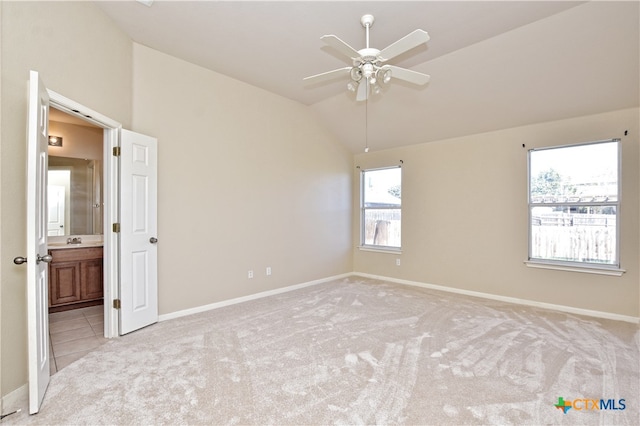 unfurnished room with light colored carpet, vaulted ceiling, ceiling fan, and sink