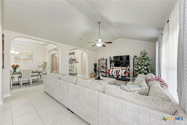 tiled living room with ceiling fan with notable chandelier and lofted ceiling