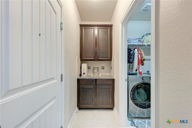 washroom featuring light tile patterned floors, a textured ceiling, and washer / clothes dryer