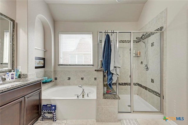 bathroom with vanity, separate shower and tub, and vaulted ceiling