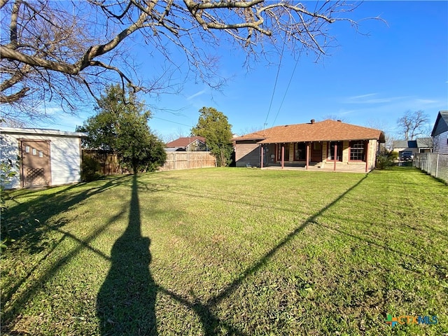 view of yard featuring a storage shed and a patio