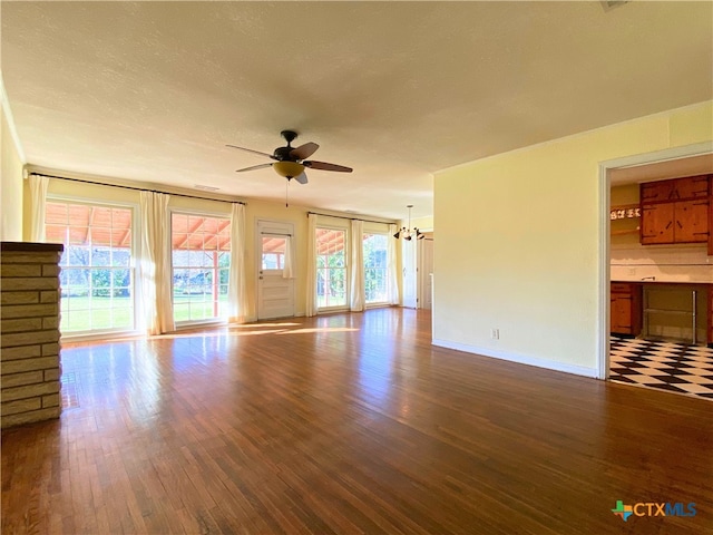 unfurnished living room with ceiling fan with notable chandelier and wood-type flooring