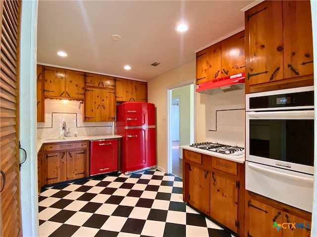 kitchen with sink, white appliances, and tasteful backsplash