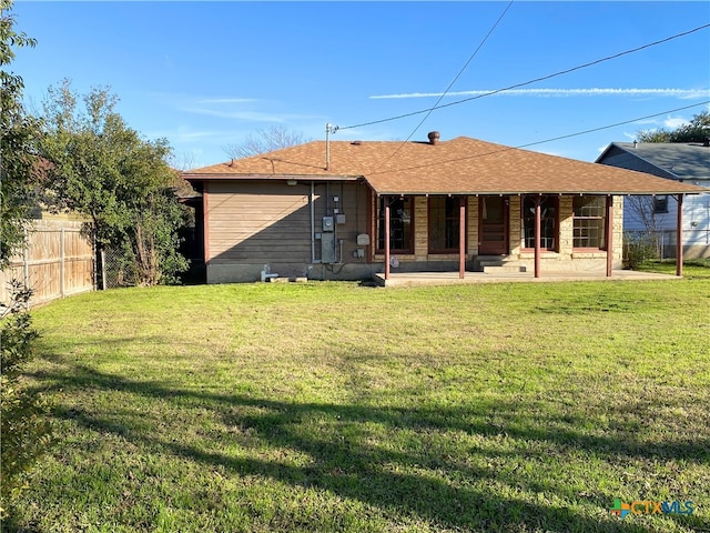 rear view of property with a patio and a lawn