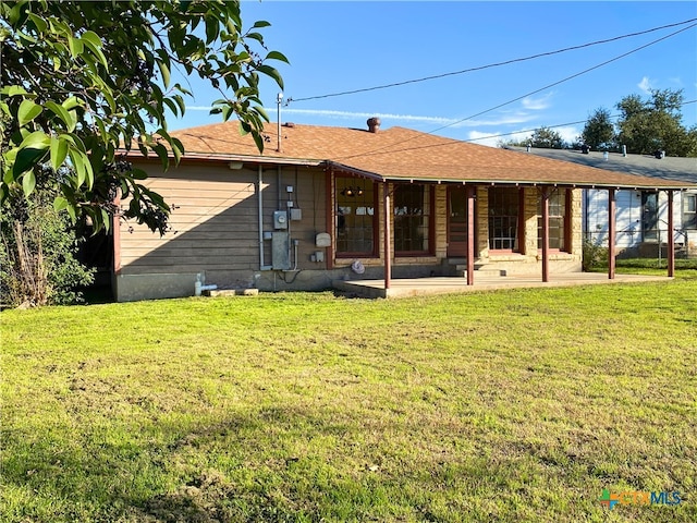 rear view of house with a lawn and a patio