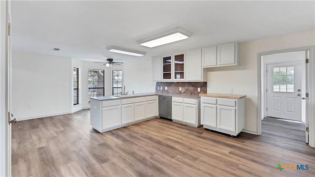 kitchen with kitchen peninsula, ceiling fan, sink, light hardwood / wood-style flooring, and white cabinetry