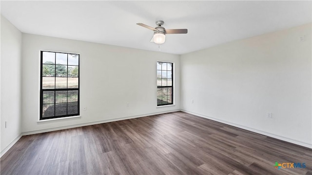 empty room featuring dark hardwood / wood-style flooring, ceiling fan, and plenty of natural light