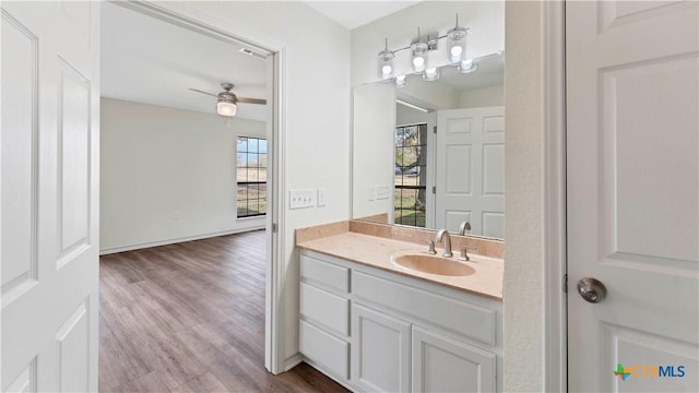 bathroom with hardwood / wood-style floors, ceiling fan, and vanity