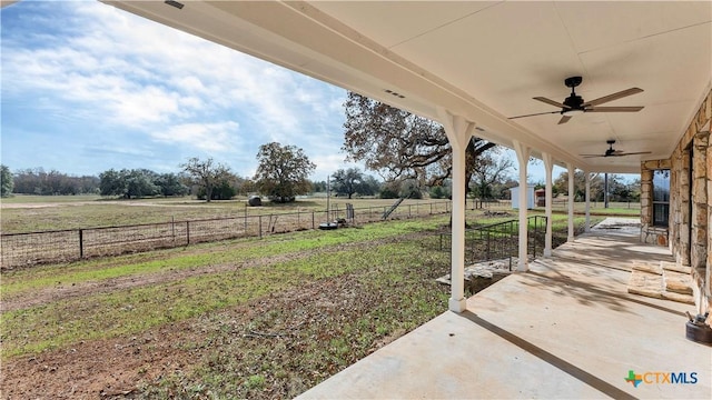 view of yard with ceiling fan, a patio, and a rural view