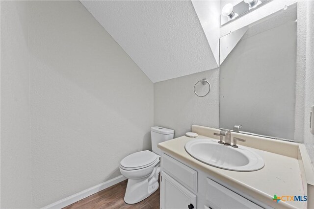 1311 Speight Ave, Waco, TX 76706 - bathroom featuring hardwood / wood-style flooring, vanity, vaulted ceiling, and toilet