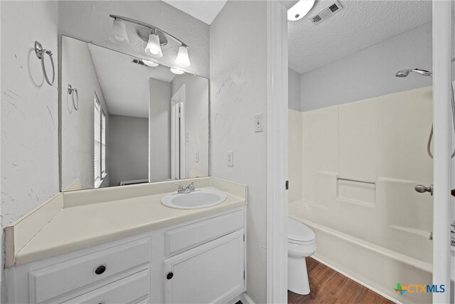 1311 Speight Ave, Waco, TX 76706 - full bathroom with shower / bathing tub combination, wood-type flooring, vanity, toilet, and a textured ceiling