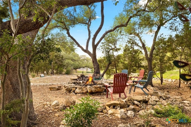 1204 Salt Lick Dr, New Braunfels, TX 78132 - view of yard featuring a fire pit and view of wooded area