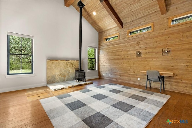 1204 Salt Lick Dr, New Braunfels, TX 78132 - unfurnished living room with high vaulted ceiling, a wood stove, wooden walls, beam ceiling, and hardwood / wood-style floors