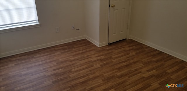 unfurnished room with dark hardwood / wood-style flooring