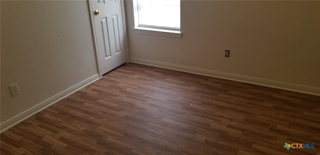 unfurnished room featuring dark wood-type flooring