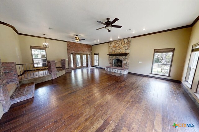 1260 Great Oaks Dr, Salado, TX 76571 - unfurnished living room with ornamental molding, a stone fireplace, hardwood / wood-style floors, a chandelier, and a ceiling fan