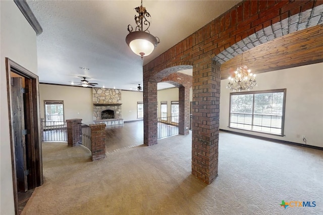 1260 Great Oaks Dr, Salado, TX 76571 - kitchen featuring decorative columns, carpet floors, ceiling fan, a fireplace, and healthy amount of natural light