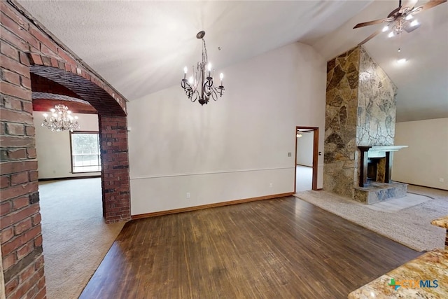 1260 Great Oaks Dr, Salado, TX 76571 - unfurnished dining area featuring a chandelier, vaulted ceiling, wood finished floors, a large fireplace, and ceiling fan