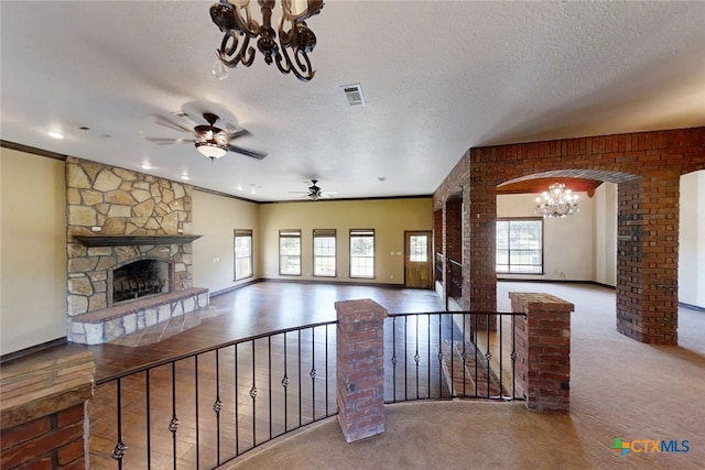 1260 Great Oaks Dr, Salado, TX 76571 - unfurnished living room featuring a chandelier, a fireplace, ceiling fan, a textured ceiling, and carpet floors