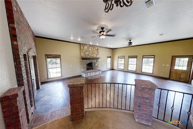 1260 Great Oaks Dr, Salado, TX 76571 - unfurnished living room featuring a stone fireplace, a ceiling fan, a textured ceiling, crown molding, and recessed lighting
